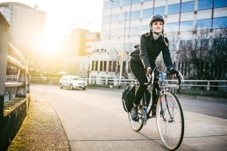 Kvinna på cykel i stadsmiljö