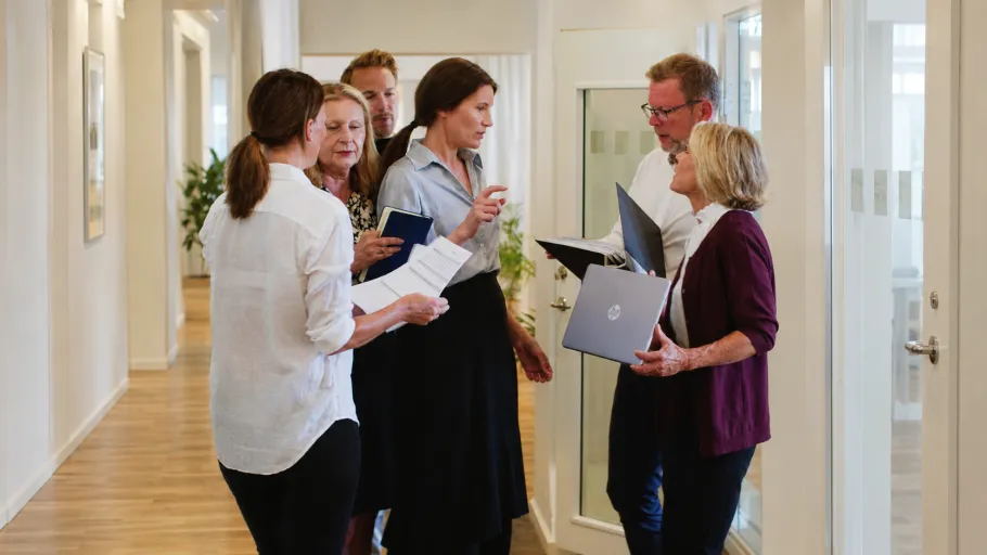 stressad chef i mitten av flera medarbetare