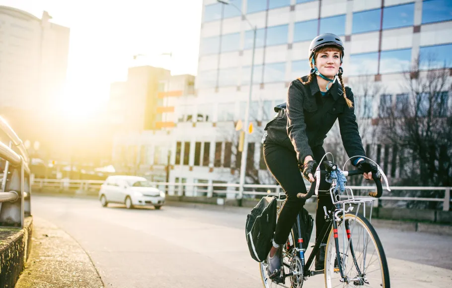Kvinna på cykel i stadsmiljö
