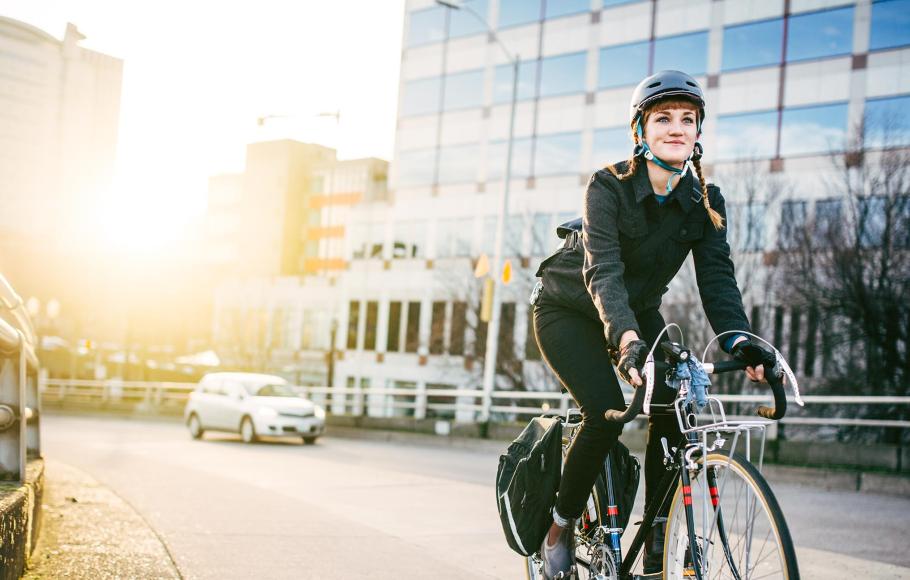 Kvinna på cykel i stadsmiljö