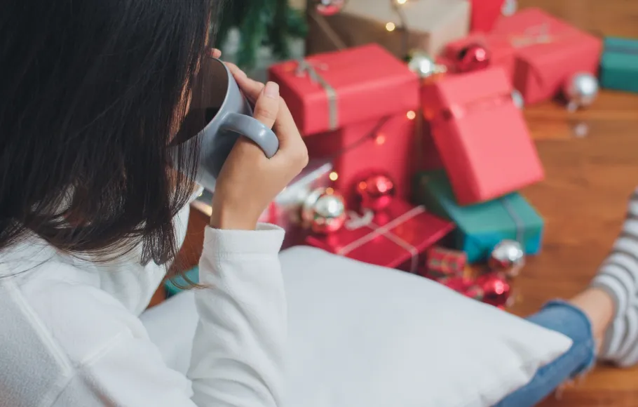 Kvinna dricker the bland alla julklappar
