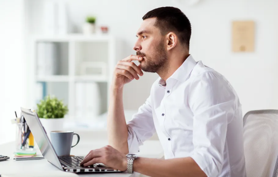 Man funderar framför datorn