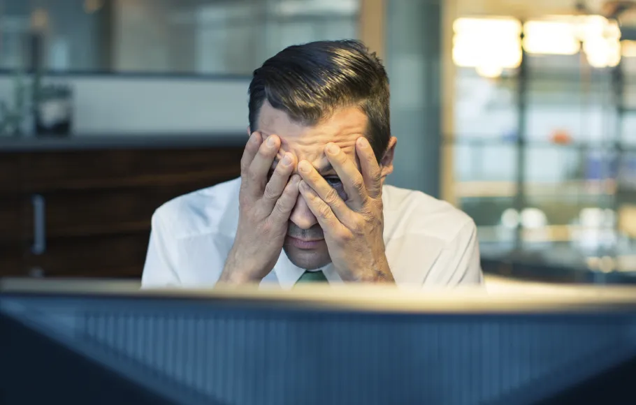 man framför dator mår dåligt