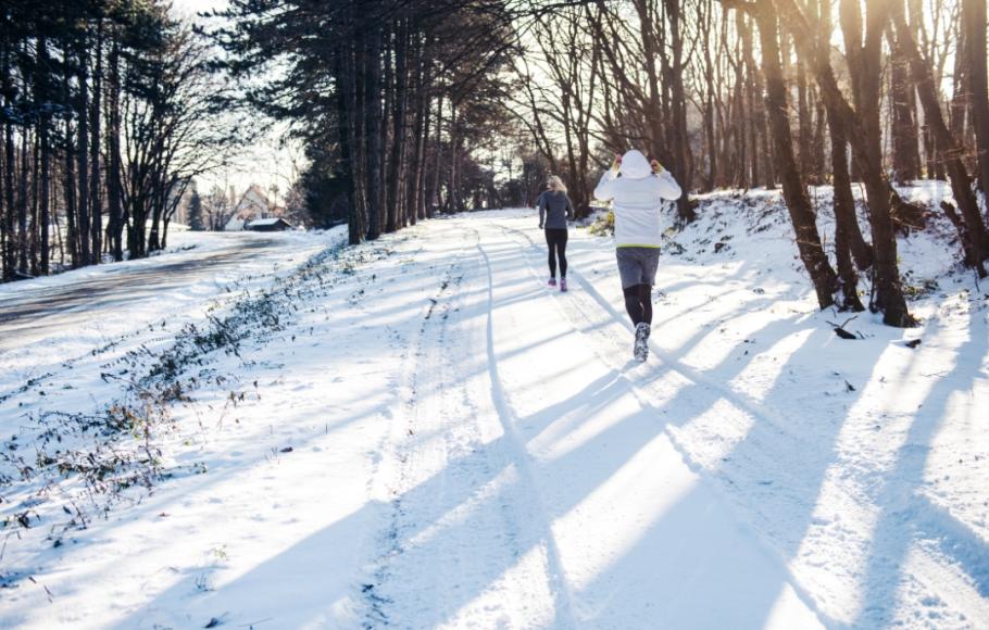 Två personer joggar på vintern