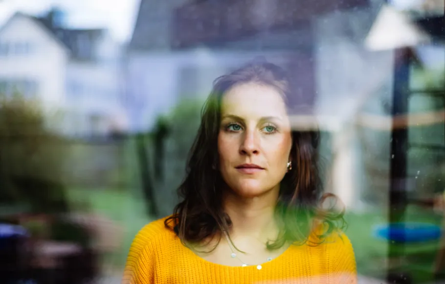 Kvinna tittar ut genom fönster