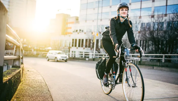 Kvinna på cykel i stadsmiljö