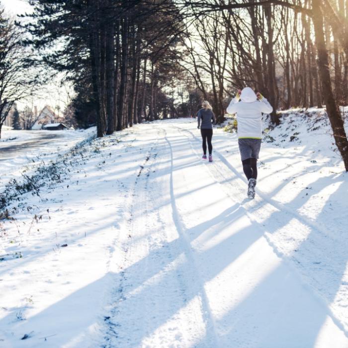 Två personer joggar på vintern