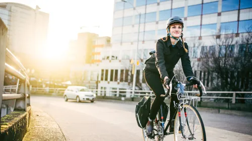 Kvinna på cykel i stadsmiljö