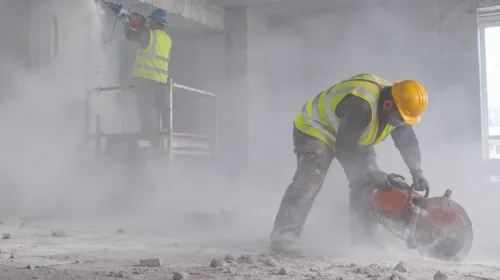 Arbetare i dammig betongmiljö